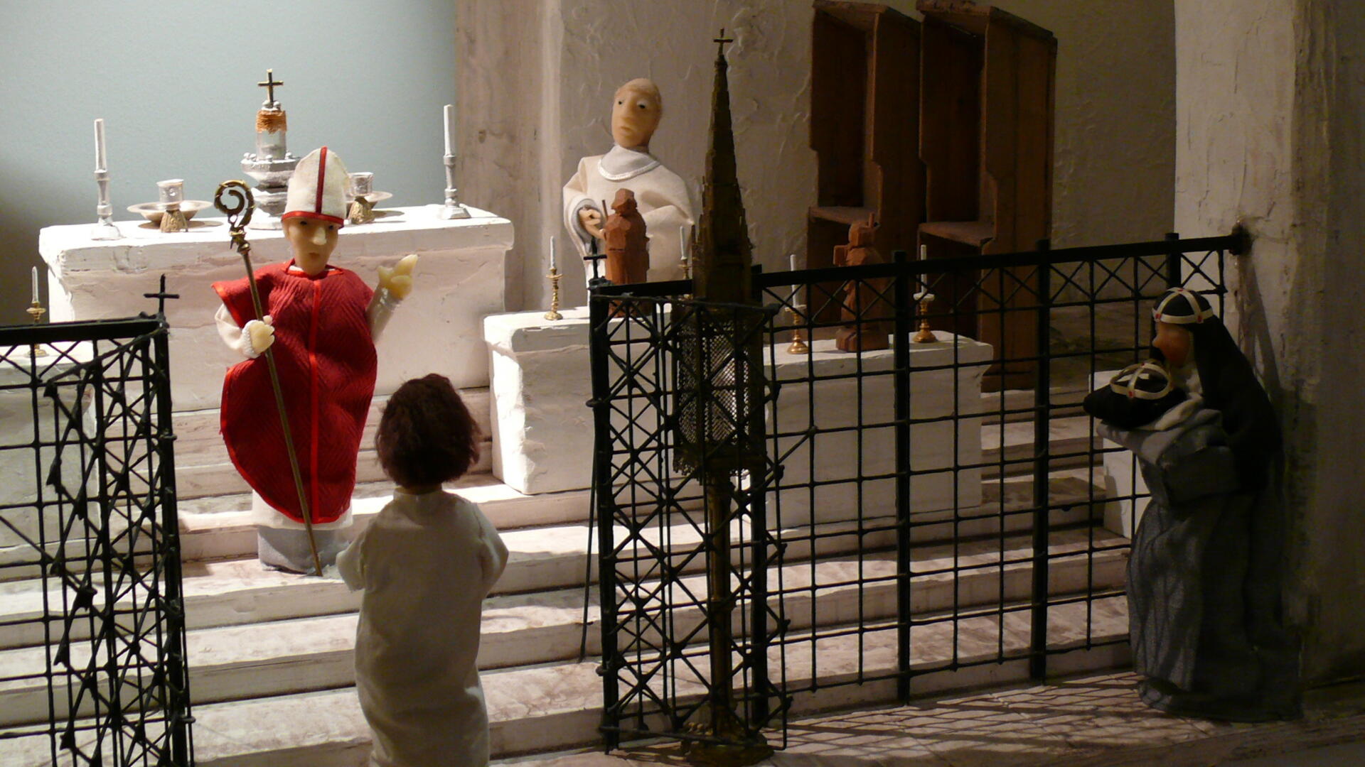 Pienoismallissa luostarikirkon alttarilla piispa siunaa uuden nunnan