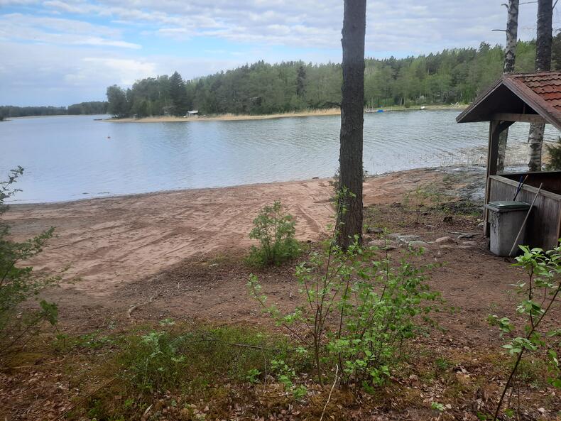 Sannaisten rannalla näkyy laajempi ranta-alue, oikealla grillikatos.