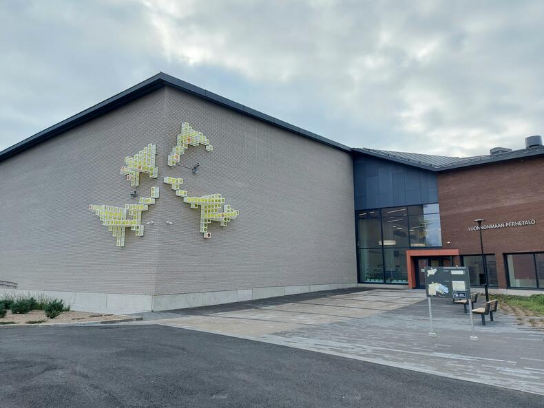 Auringon kulma -niminen julkinen taideteos Luonnonmaan perhetalon julkisivussa.