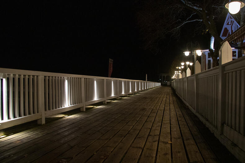 Kaiteiden alta tulevat valot osoittavat alas päin rannan laitureilla.