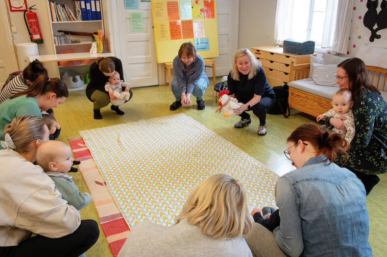 Aikuisia vauvojen kanssa piirissä ohjatussa vauvaryhmässä Väentuvan avoimessa päiväkodissa.