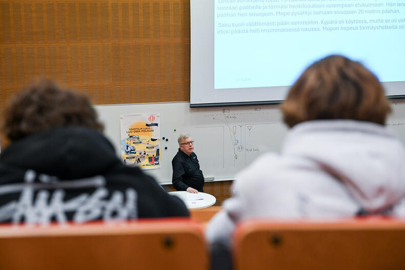 Liikenneturvan työntekijä luennoimassa nuorille auditoriossa.