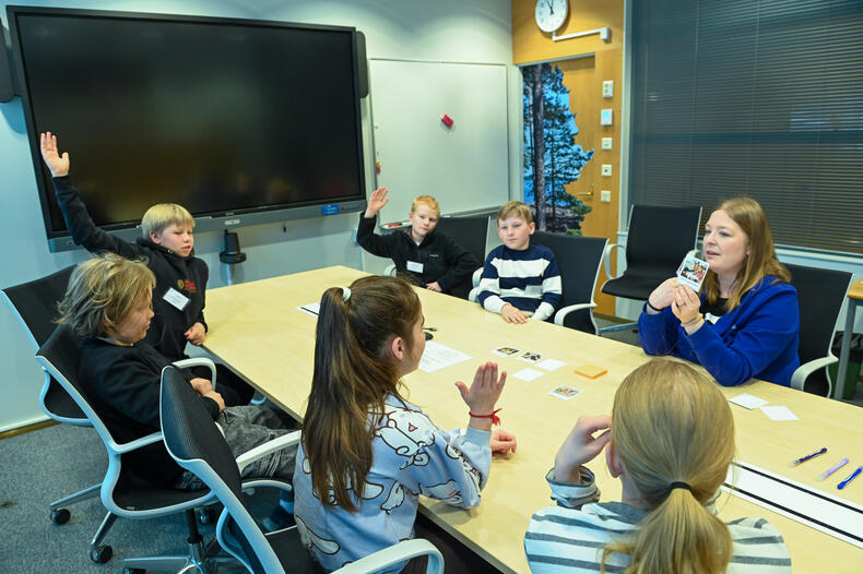 Naantalilaisia lapsia Lasten parlamentin työpajassa. Lapset viittaavat.