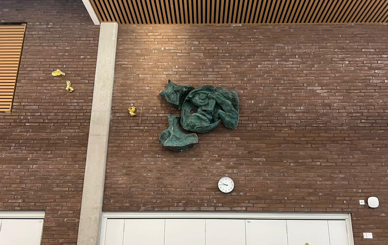 Osa Benjamin Orlowin taideteoksesta Luonnonmaan perhetalossa kiinnitettynä tuloaulan tiiliseinään.