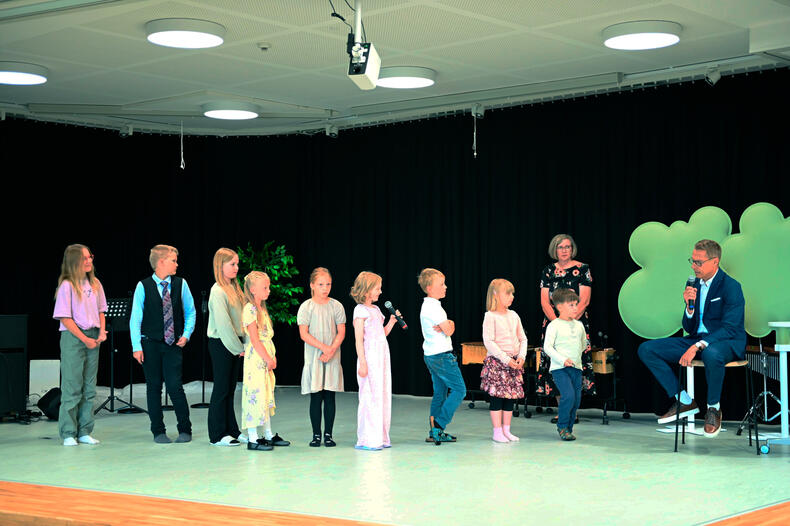 Lapset kysyvät jonossa kysymyksiä presidentti Stubbilta.
