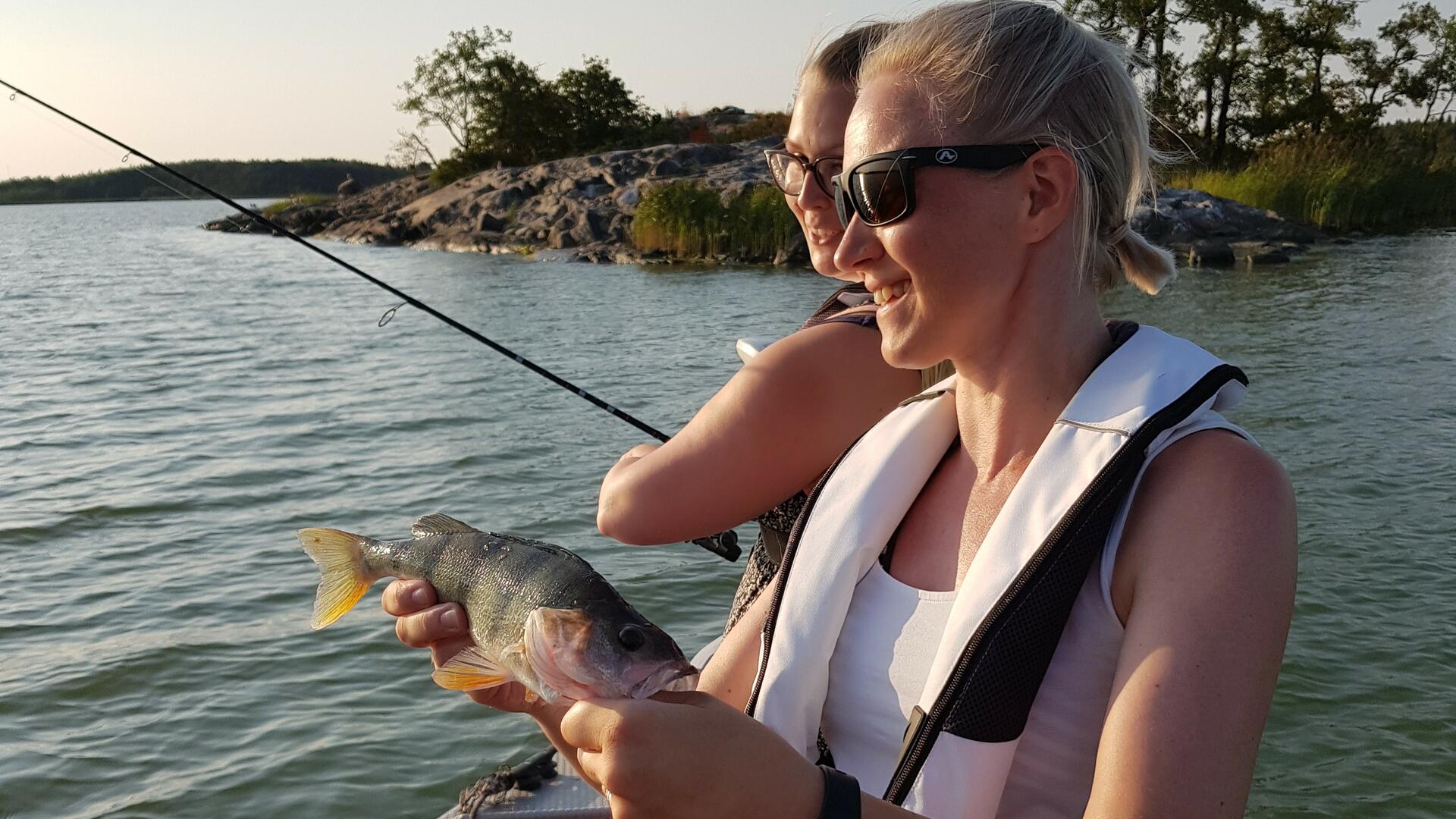 Naiset kalastamassa veneessä.