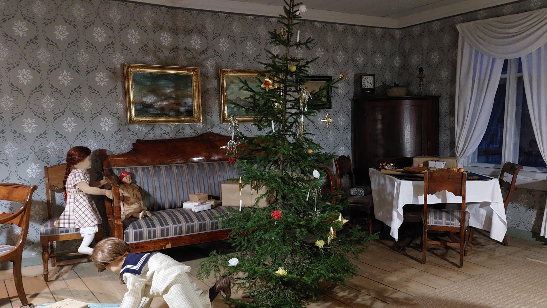 Museon salissa leikkiviä lapsia ja joulukuusi