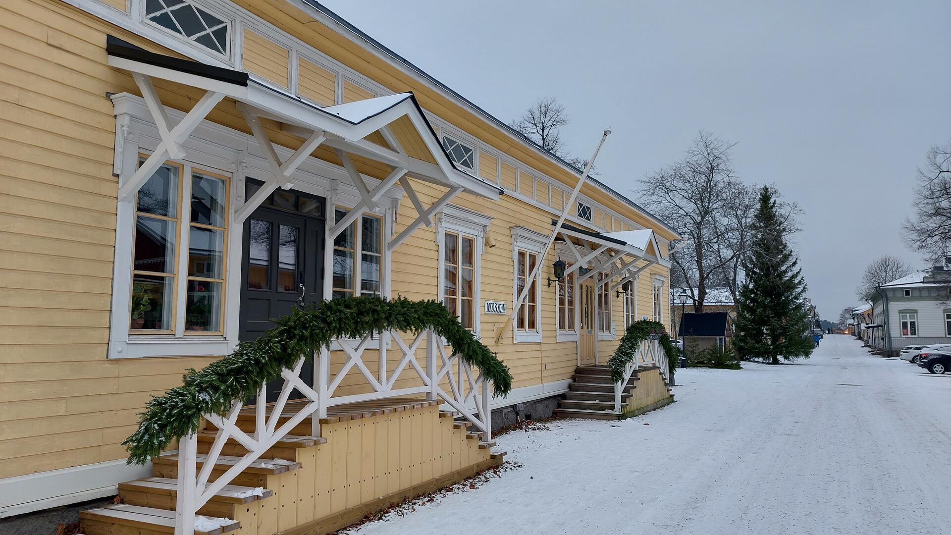 keltaiseksi maalattu puurakennus kadun varressa