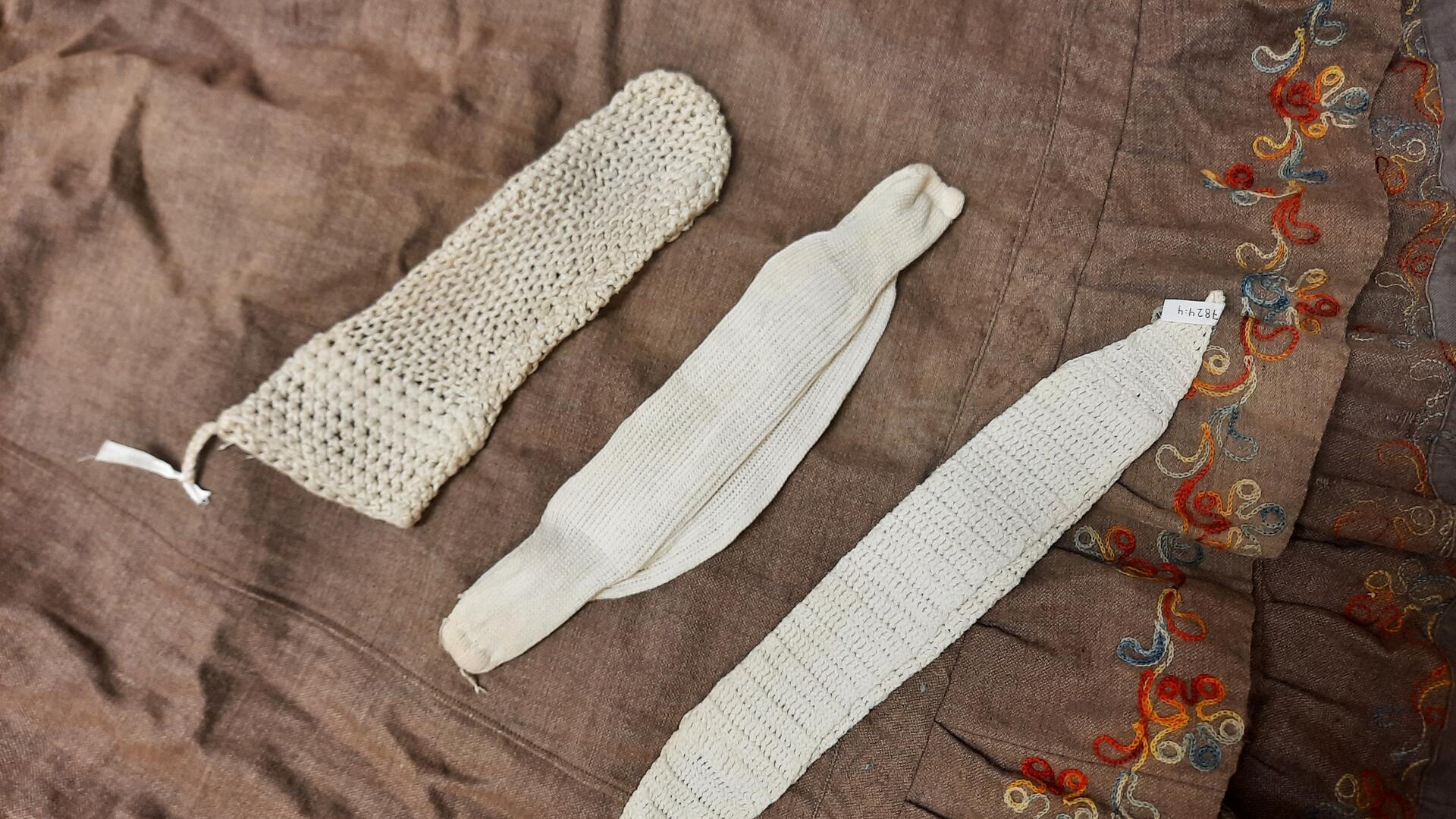 Ruskealla pohjakankaalla kolme valkoista vanhanaikaista kuukautissuojaa