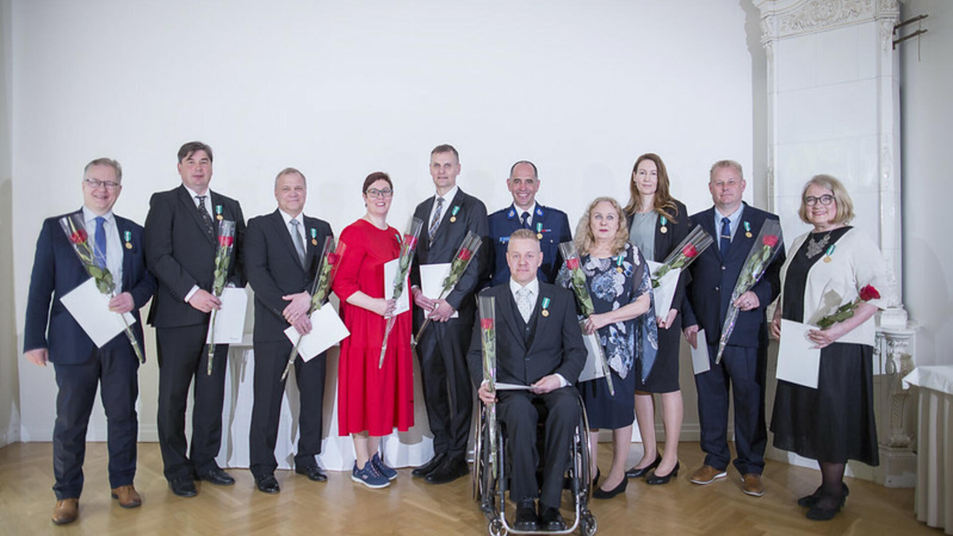 11 palkittua yhteiskuvassa ruusut ja diplomit käsissään.