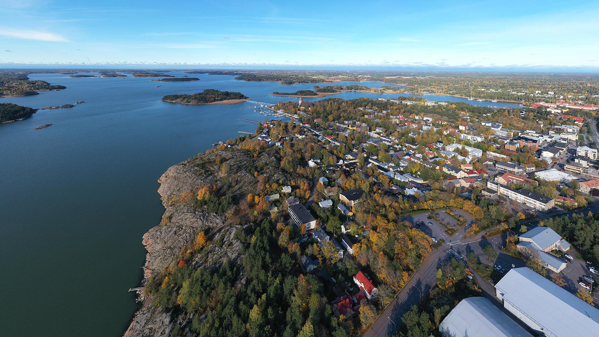 Syksyistä Naantalia ympäröi meri. Etualalla jäähallit Kuparivuoressa, pidemmällä kohoaa Naantalin luostarikirkko.