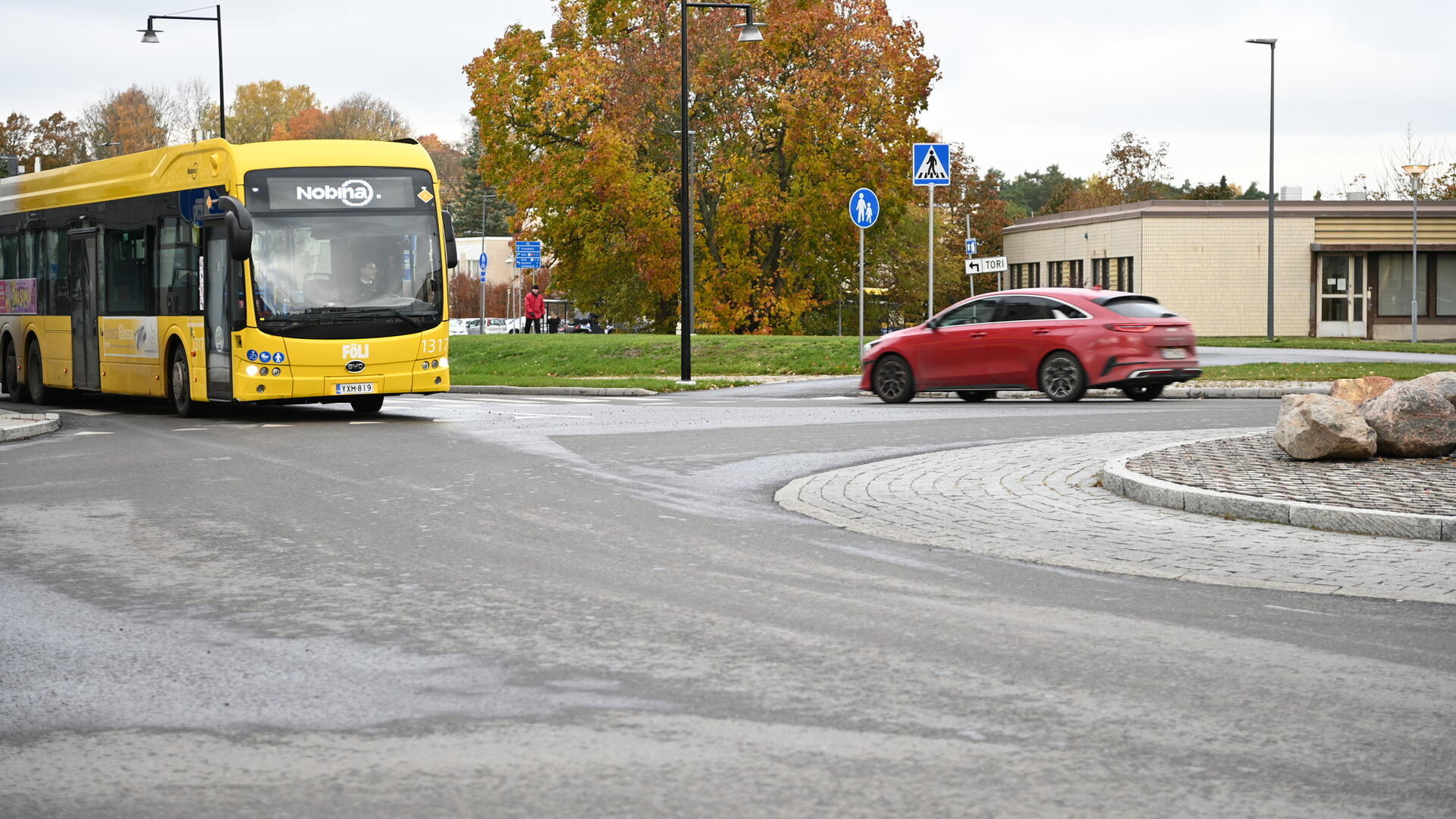 Linja-auto ja henkilöauto kiertoliittymässä Naantalissa.