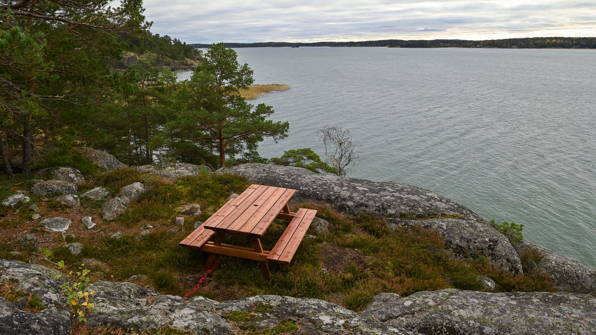 Istuinryhmä kalliolla, edessä avautuu merimaisema.