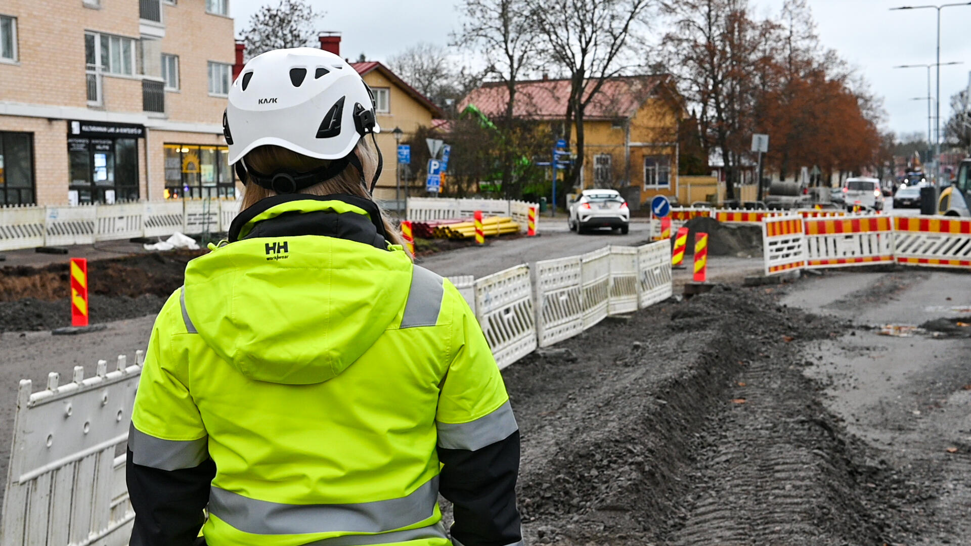 Työnjohtaja valvoo työmaata selkä kameraan päin Naantalin Kaivokadulla.