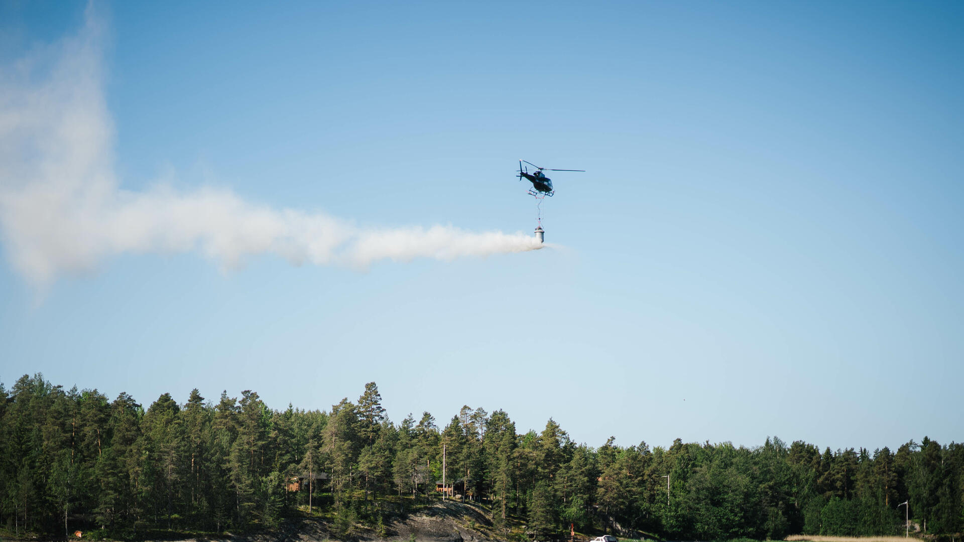 Helikopteri levittää kalkkikiveä meren yllä.