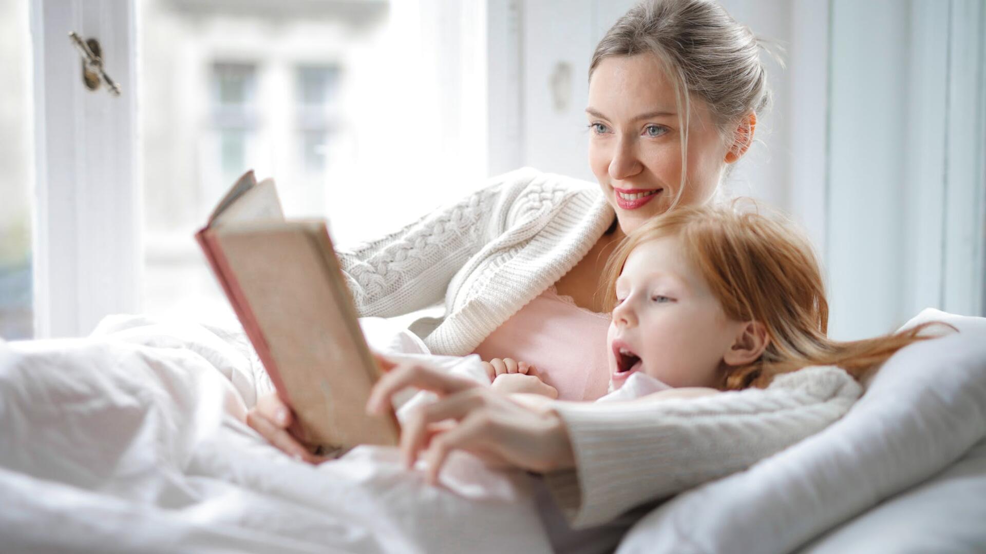 Nainen lukemassa kirjaa lapselle