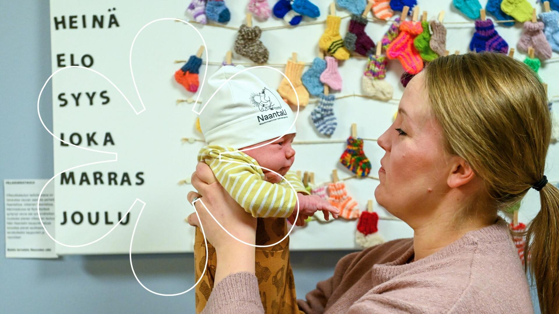 Äiti pitelee sylissään pientä lasta.