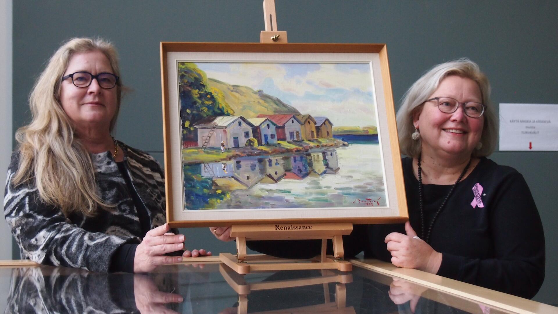 kaksi naista esittelee öljyvärimaalausta