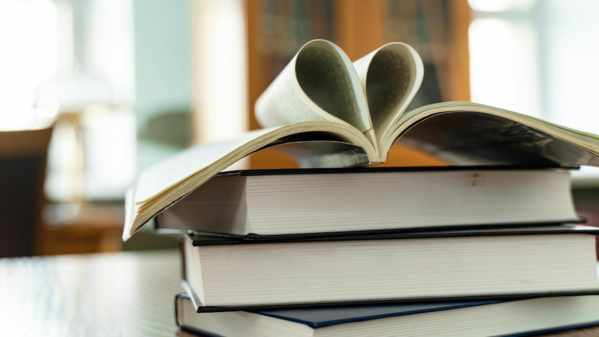 Kirjoja pinossa pöydällä