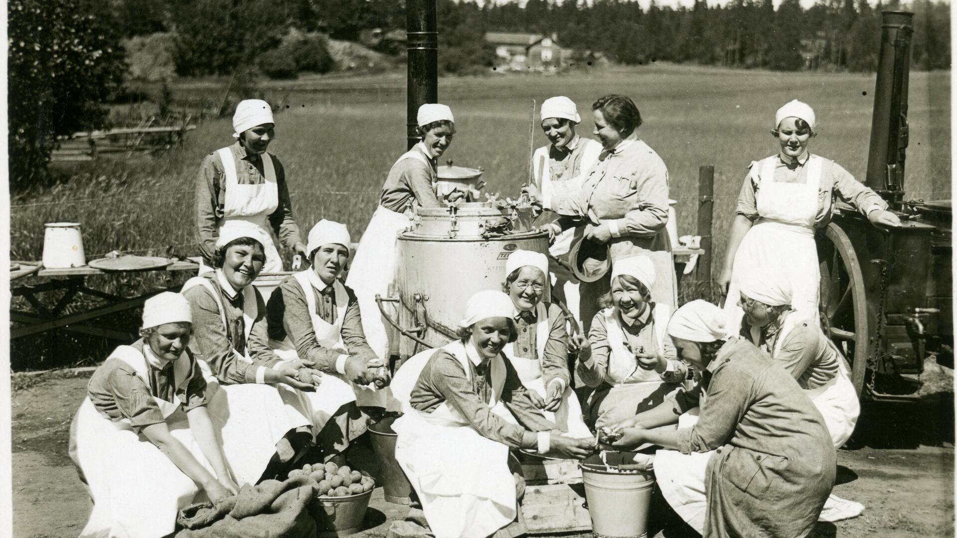 Ryhmäkuva lotta-asuisista naisista kenttäkeittiön edessä