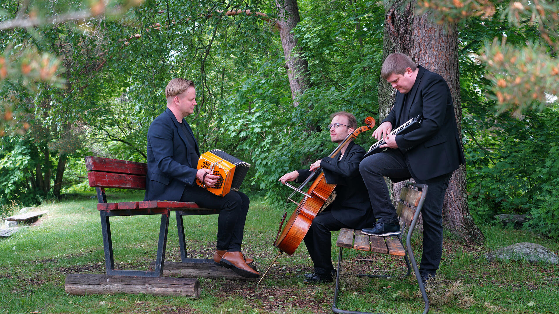 Tango del norte -yhtyeen muusikot soittimineen puiston penkillä.