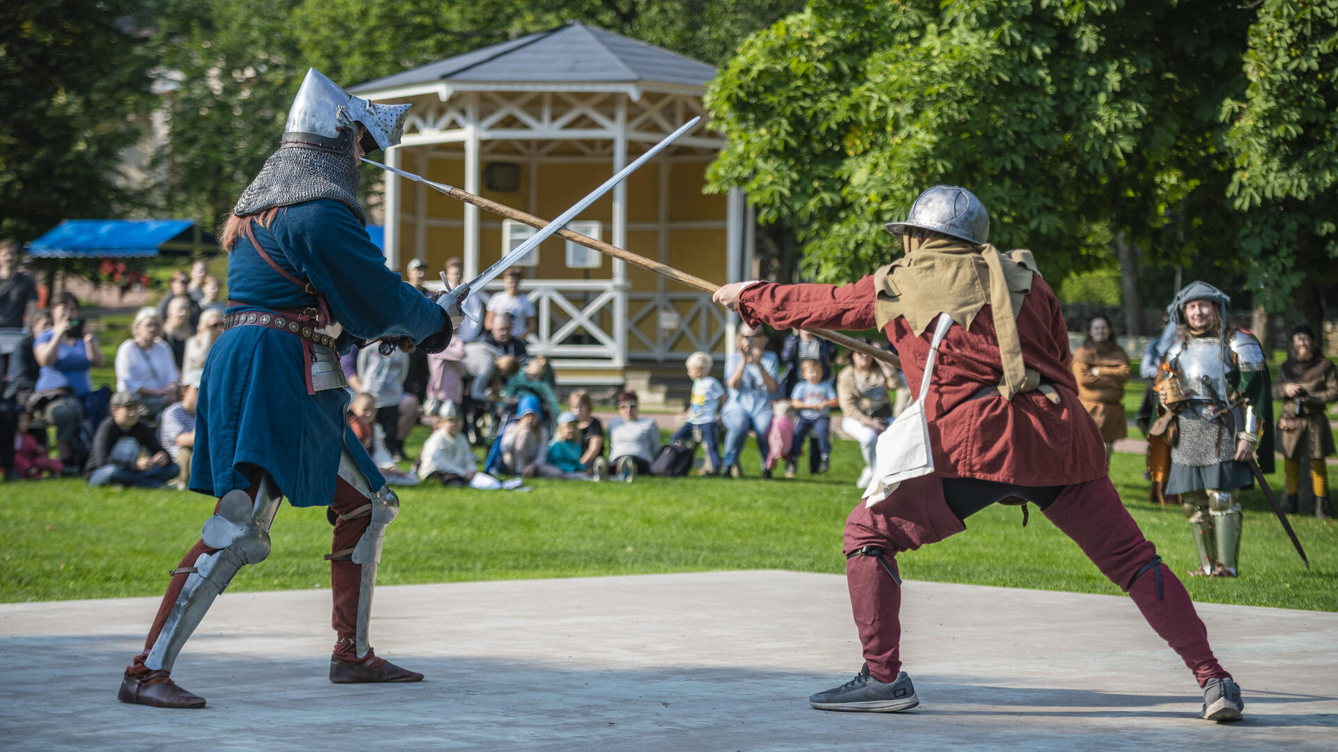 Keskiaikatapahtumassa kaksi haarniskaan puettua taistelijaa miekkailee.