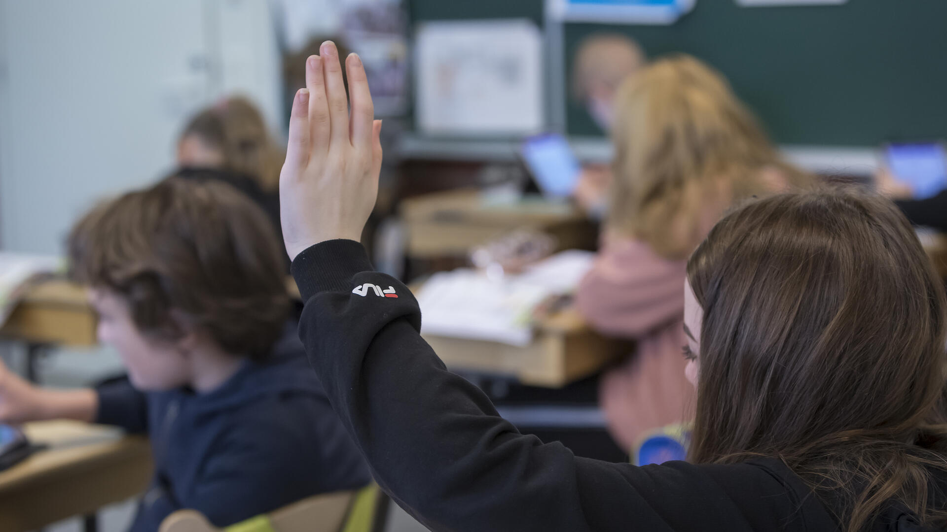 Oppilas viittaa luokassa.