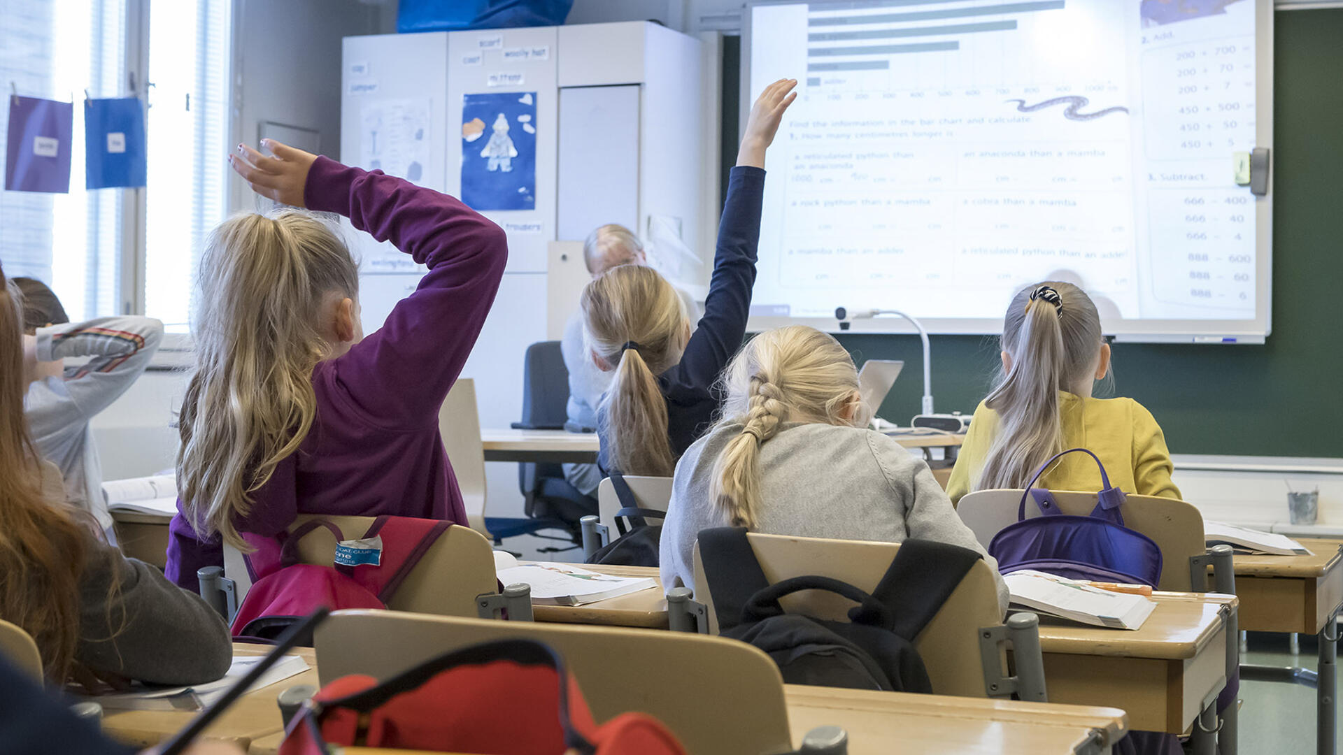 Oppilaat viittaavat luokassa.