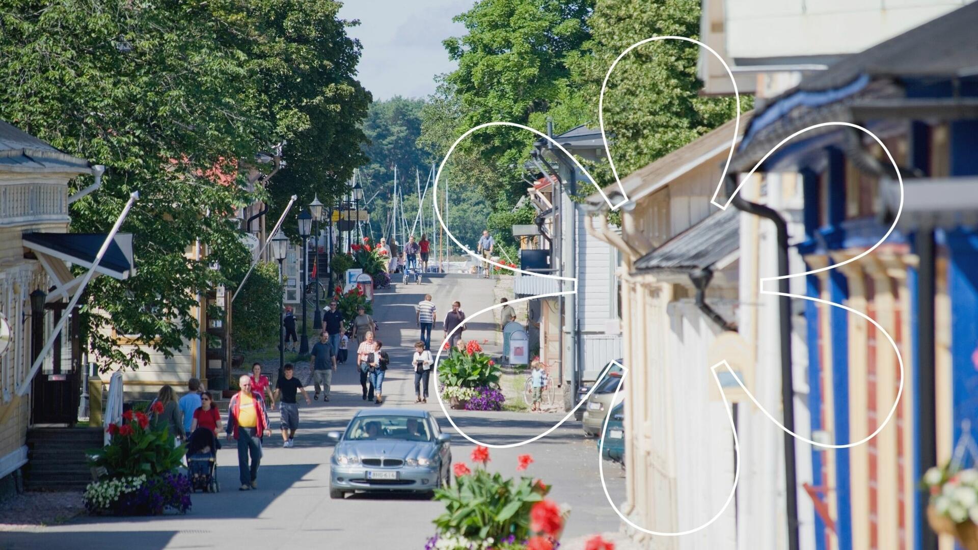 Ihmisiä kulkee puutalojen välissä Mannerheiminkatua pitkin kesäisessä Vanhassakaupungissa Naantalissa.