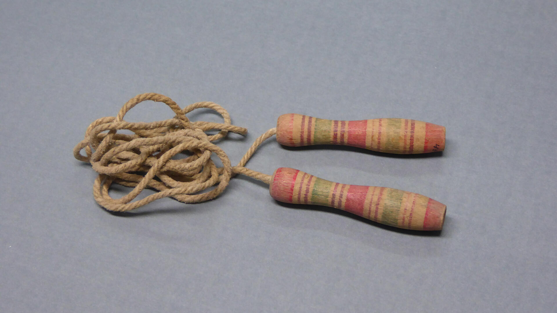 harmaalla taustalla hyppynaru, jossa puiset kädensijat