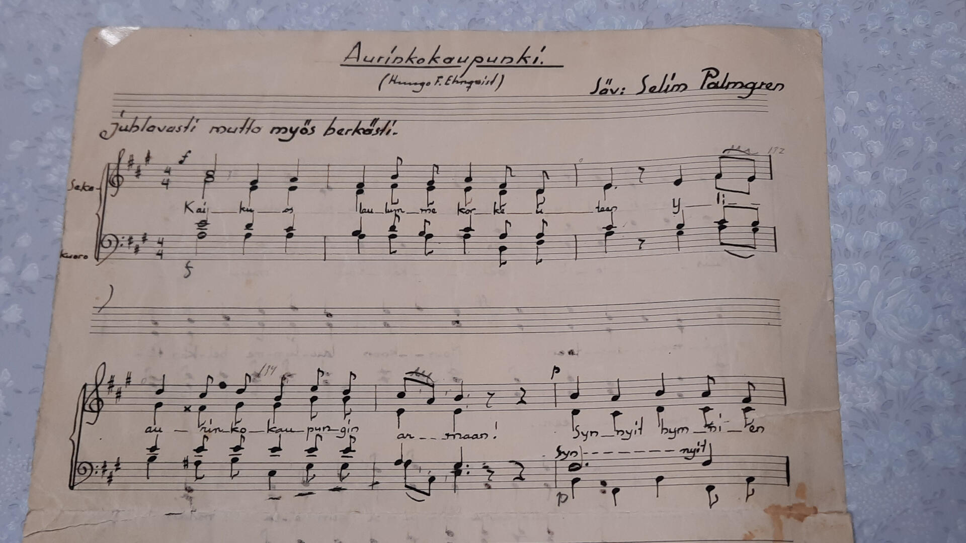 Käsinkirjoitettu arkki, nuottirivit ja sanat