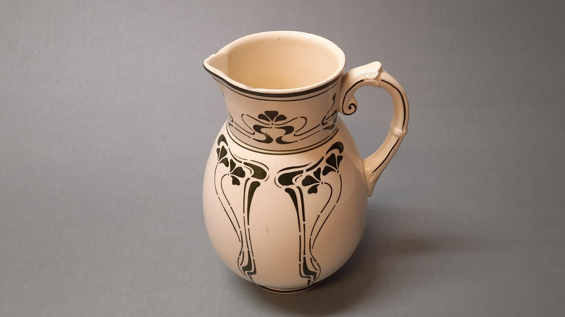 valkoinen keraaminen kannu, jossa on mustia koristekuvioita