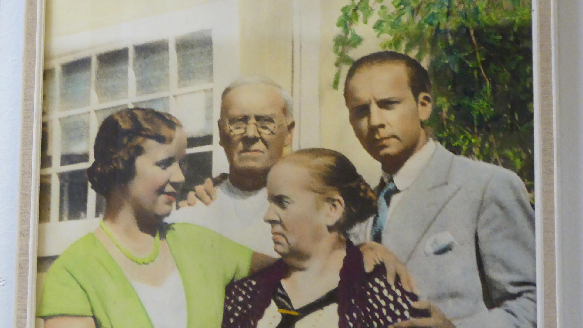 vanhempi ja nuorempi pariskunta rakennuksen edessä