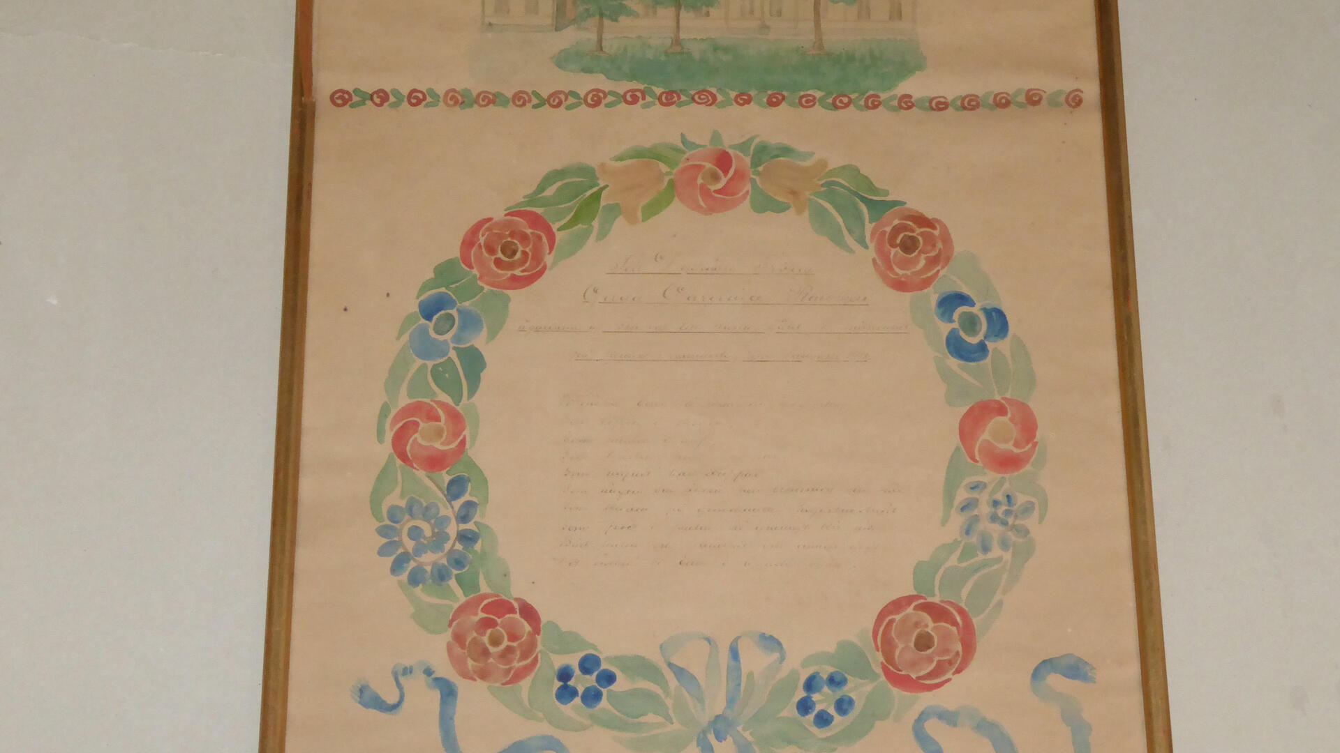 Kehystetty nimipäivätaulu, jossa on akvarellivärein maalatun kukkakranssin sisällä tekstiä