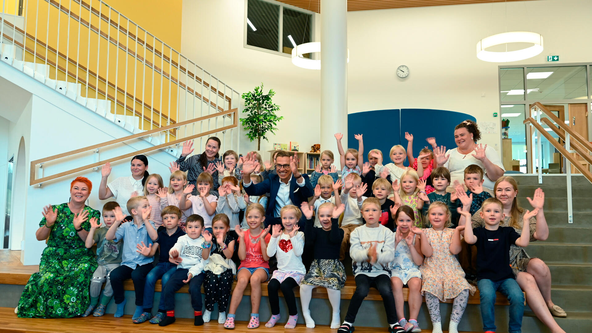 Presidentti Stubb vilkuttaa Luonnonmaan perhetalon lasten kanssa kameroille.