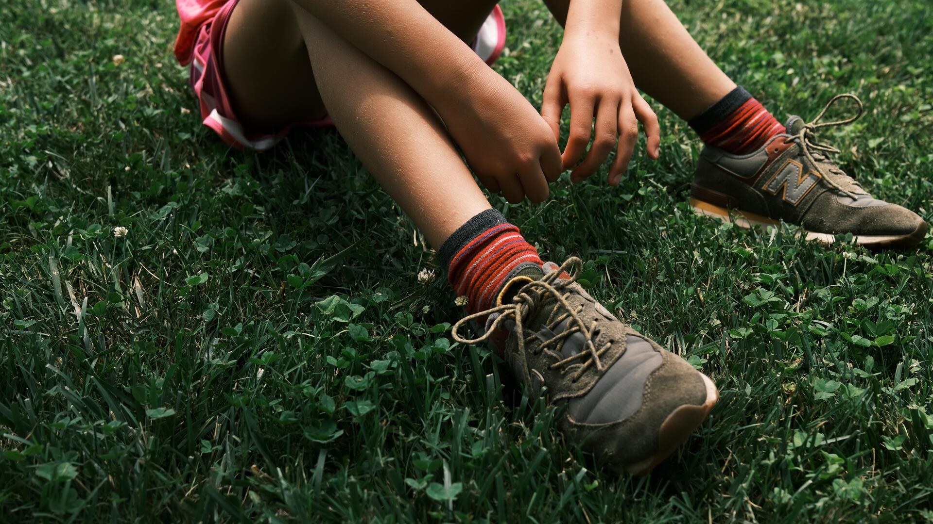 Lapsi istuu nurmikolla.