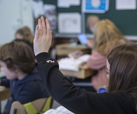 Oppilas viittaa luokassa.