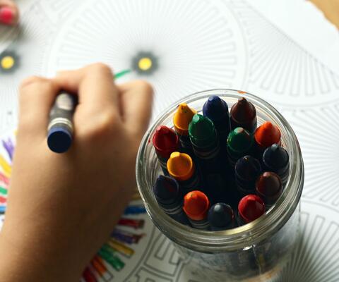 Lapsi piirtää värikynillä paperiin