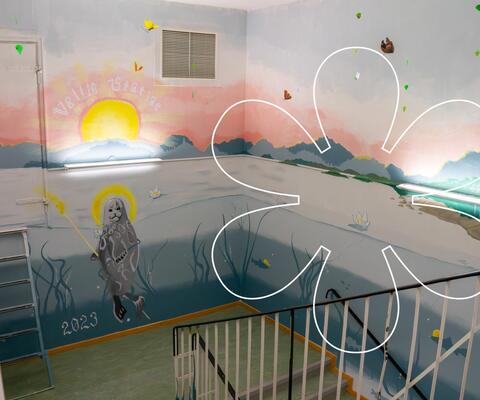 Portaikkoon maalattu murtovesimaisemaa, jossa keskellä saimaannorppa ja aurinko. Kuvan päällä Onnellinen aurinko -elementti.