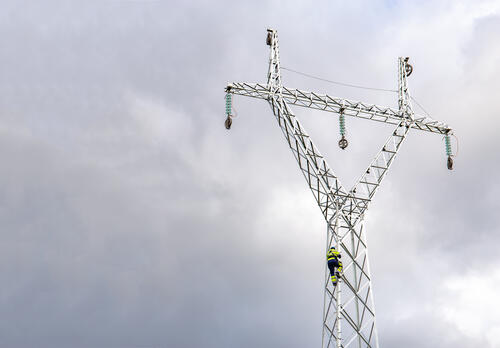 Sähköpylväs tavasta vasten.