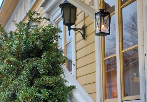 Havuköynnös Naantalin museon portailla ja taustalla kynttilälyhty ikkunan edessä.