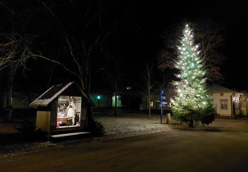 Valaistu joulukuusi ja seimi Itsenäisyydenpuistossa pimeän aikaan.