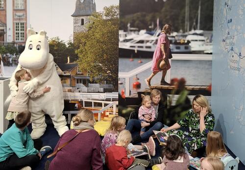 Muumipeikko ja Alma Pöysti matkamessuilla 2026 Naantalin osastolla. Kuvassa lapsia kuuntelemassa muumitarinoita.