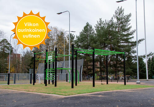 Vihreät street work -välineet asfalttisen pihan keskivaiheilla, takana peliareena. Viikon aurinkoinen uutinen