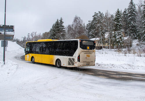 Fölin bussi numero N4 ajaa kevyessä lumisateessa loivaa mäkeä ylös Luonnonmaalla.