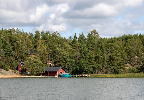 Punaisia rakennuksia meren rannalla Rymättylässä.