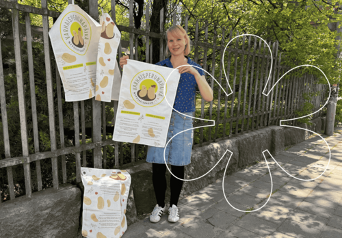 Yrittäjä Anna Hormio pitelee varhaisperunapäivän uuden ilmeen mukaisia keittiöpyyhkeitä.