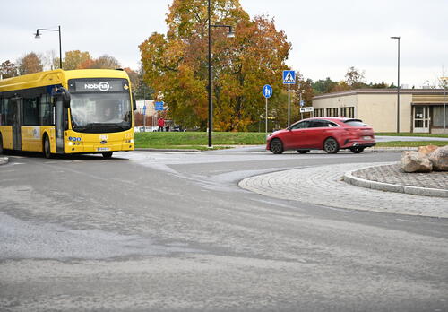 Linja-auto ja henkilöauto kiertoliittymässä Naantalissa.