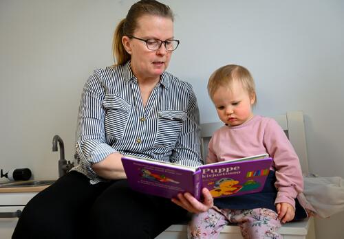 Perhepäivähoitaja lukee satua pienelle lapselle.