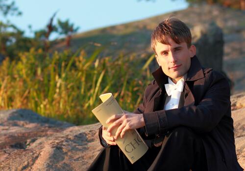 Pianisti Henrik Järvi istuu kalliolla ilta-auringossa.
